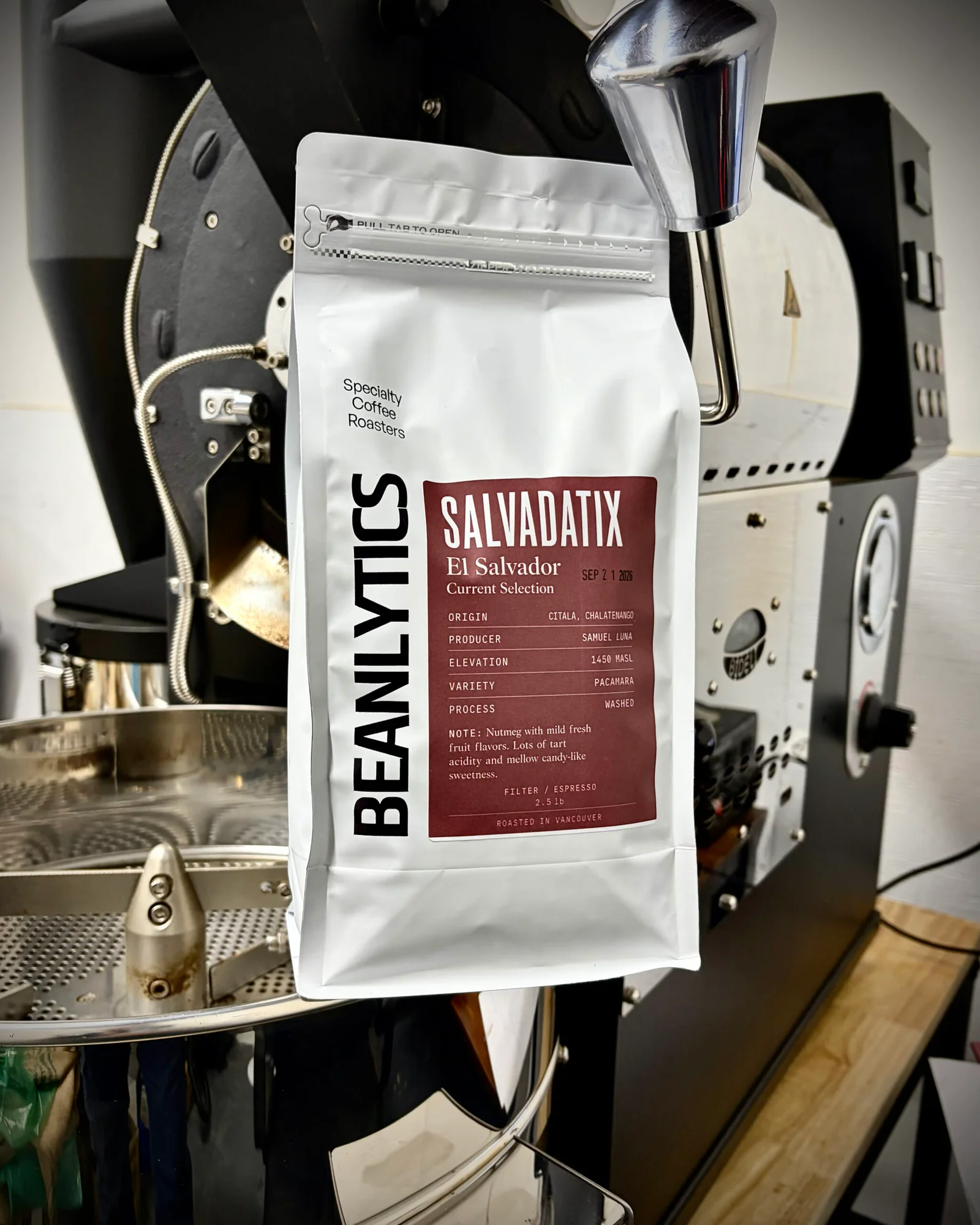 Beanlytics Salvadatix El Salvador Pacamara coffee bag in front of coffee roaster