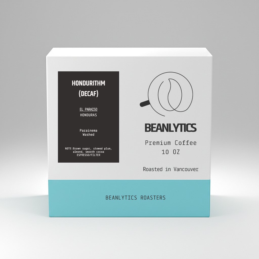 A white and teal coffee box labeled 'Beanalytics Premium Coffee 10 oz – Roasted in Vancouver.' The left side features a black label reading 'Hondurithm (Decaf), El Paraiso, Honduras, Parainema, Washed' with tasting notes of brown sugar, stewed plum, almond, and smooth cocoa, suitable for espresso or filter brewing. The Beanalytics logo, a stylized coffee bean outline, appears prominently above the brand name.